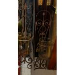 TWO WALL HANGING SCROLLED WROUGHT IRON AND GLASS GARDEN STORM LANTERNS Having spherical glass