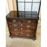 AN EARLY 18TH CENTURY OAK CHEST OF DRAWERS Having a plank top and two short and three long oak lined