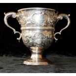 A GEORGIAN IRISH SILVER LOVING CUP Having twin handles, fine embossed decoration and an engraved