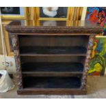 A VICTORIAN OAK HEAVILY CARVED FLOORSTANDING OPEN BOOKCASE With heavily carved decoration in the