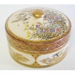 A JAPANESE MEIJI SATSUMA POTTERY LIDDED BOX Spherical form, hand painted with flowers and figural