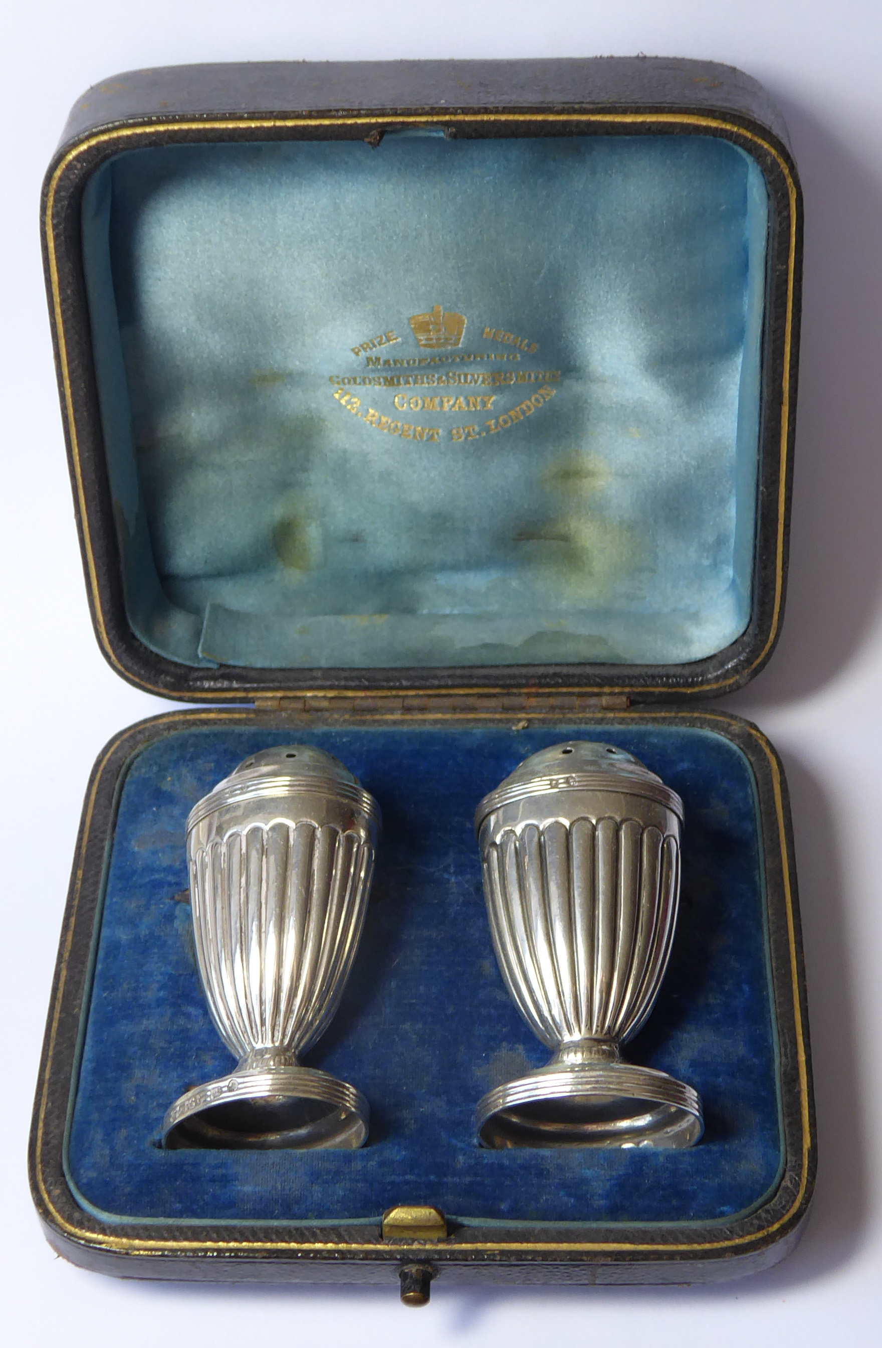 A CASED PAIR OF VICTORIAN C SILVER PEPPERETTES Classical form with flutes, in fitted velvet lined