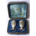 A CASED PAIR OF VICTORIAN C SILVER PEPPERETTES Classical form with flutes, in fitted velvet lined