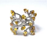 PIRANESI, AN 18CT WHITE METAL, YELLOW SAPPHIRE AND DIAMOND RING Having an arrangement of pear cut