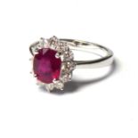 AN 18CT WHITE GOLD, RUBY AND DIAMOND RING An oval cut ruby edged with diamonds Ruby approx 0.8cm x
