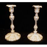 A PAIR OF EARLY 19TH CENTURY ROCOCO FORM SILVER PLATED CANDLESTICKS Finely cast with leaves,