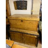A 19TH CENTURY PINE CHEST With hinged lid and iron carrying handles, on plinth base.