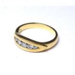 AN 18CT GOLD AND DIAMOMD FIVE STONE RING Graduating round cut stones in a rub over setting (size N).