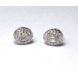 A PAIR OF 18CT WHITE GOLD AND DIAMOND STUD EARRINGS A baguette stone edged with diamonds Approx 0.