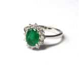 AN 18CT GOLD, EMERALD AND DIAMOND RING An oval cut emerald edge with diamonds Size O Approx 2ct