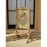 A CARVED CHIPPENDALE PERIOD GILTWOOD FIRE SCREEN Retaining original embroidered tapestry behind
