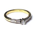 AN 18CT GOLD AND DIAMOND STEP CUT RING Having a round cut diamond flanked by tapering baguettes (