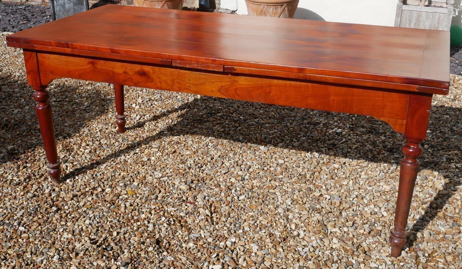 AN EARLY 20TH CENTURY FRENCH SOID CHERRYWOOD FOUR PLANK TOP DRAW LEAF TABLE With a single drawer and