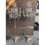 A PAIR OF GILT METAL STANDARD LAMPS Hung with crystal drops, raised on turned columns to platform