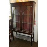 AN EDWARDIAN MAHOGANY DISPLAY CABINET With two Gothic pointed arched glazed doors above a lower