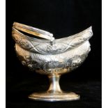 A GEORGIAN IRISH SILVER SWEETMEAT BASKET Having a swing handle, embossed floral decoration and