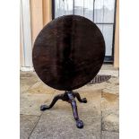 A GEORGIAN CUBAN MAHOGANY SUPPER TABLE Having a circular top supported by a birdcage, on a carved