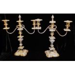 A PAIR OF EARLY 20TH CENTURY SILVER PLATE ON COPPER CANDELABRA Having twin scrolled arms and