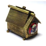 AN UNUSUAL BRASS AND ENAMEL DOG KENNEL VESTA CASE Having a hinged roof with circular enamel panel of