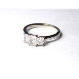 A PLATINUM AND DIAMOND THREE STONE RING A row of radiant cut stones in a stepped design. Size M