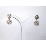 A PAIR OF 18CT WHITE GOLD AND DIAMOND DAISY CLUSTER EARRINGS An arrangement of round cut diamonds