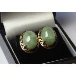 A VINTAGE PAIR OF YELLOW METAL AND JADE EARRINGS The oval cabochon cut stones set in a classical