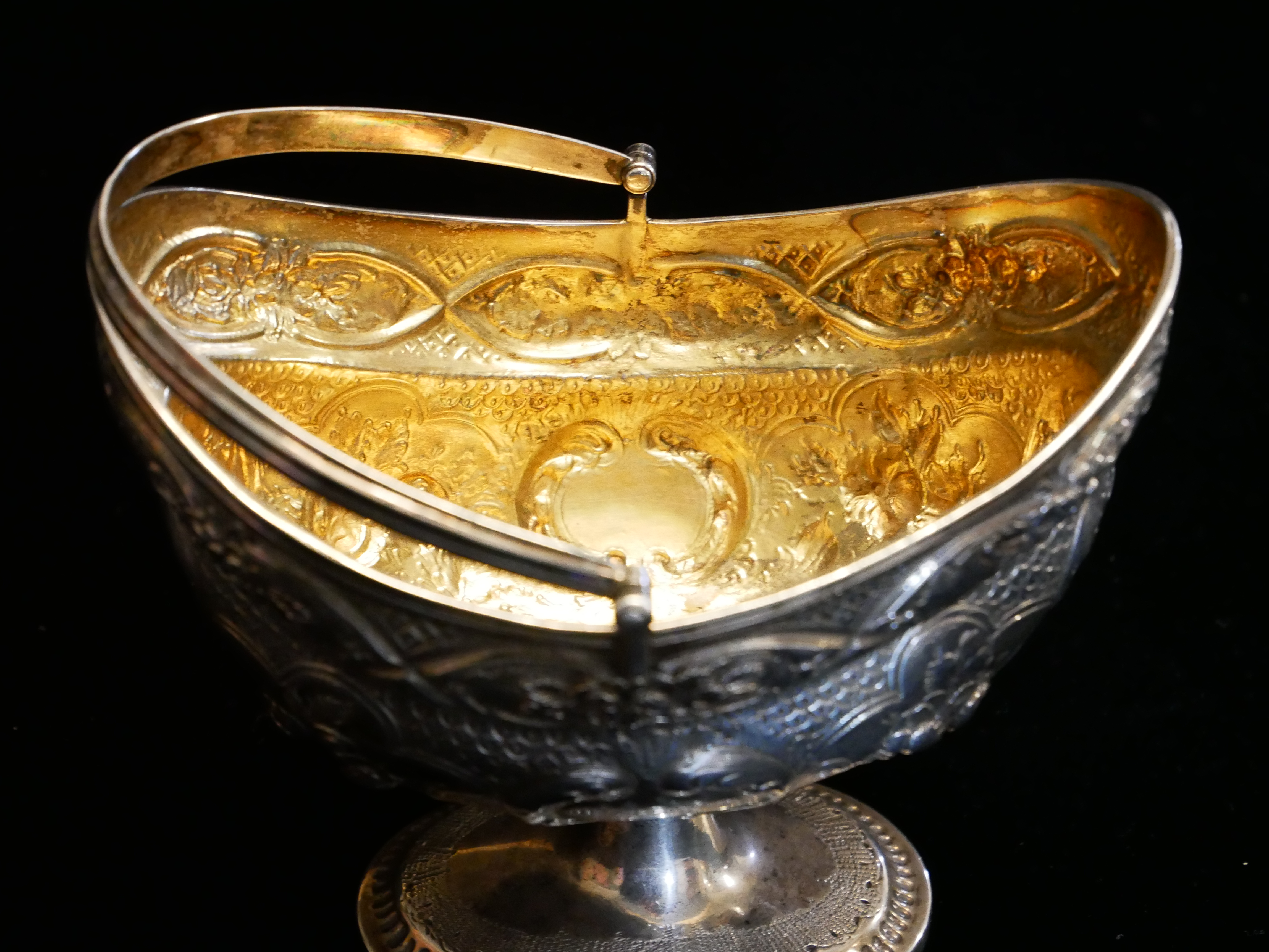 A GEORGIAN IRISH SILVER SWEETMEAT BASKET Having a swing handle, embossed floral decoration and - Image 3 of 5