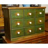 A RUSTIC PINE PAINED AND DISTRESSED BANK OF NINETEEN DRAWERS.