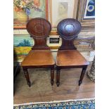 A PAIR OF EARLY 19TH CENTURY MAHOGANY HALL CHAIRS With oval backs solid seats raised on turned