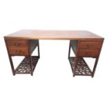 A CHINESE HARDWOOD DESK With an arrangement of four drawers above lattice work under tiers. (160cm x