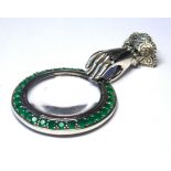 A SILVER NOVELTY AND PASTE SET 'HAND' MAGNIFYING GLASS Tudor form hand with lace cuff set with green