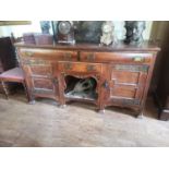 AN ART NOVEAU PERIOD AND DESIGN OAK DRESSER With an arrangement of three drawers and cupboards and