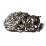 A STERLING SILVER NOVELTY MODEL OF A RECUMBENT CAT Having a pierced scrolled design. (approx 3.5cm)