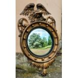 A REGENCY PERIOD CONVEX MIRROR Original plates, retained in a circular ebony reeded boarder