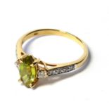 AN 18CT GOLD TOURMALINE AND DIAMOND RING The oval cut stone with diamond set shoulders (size N). (