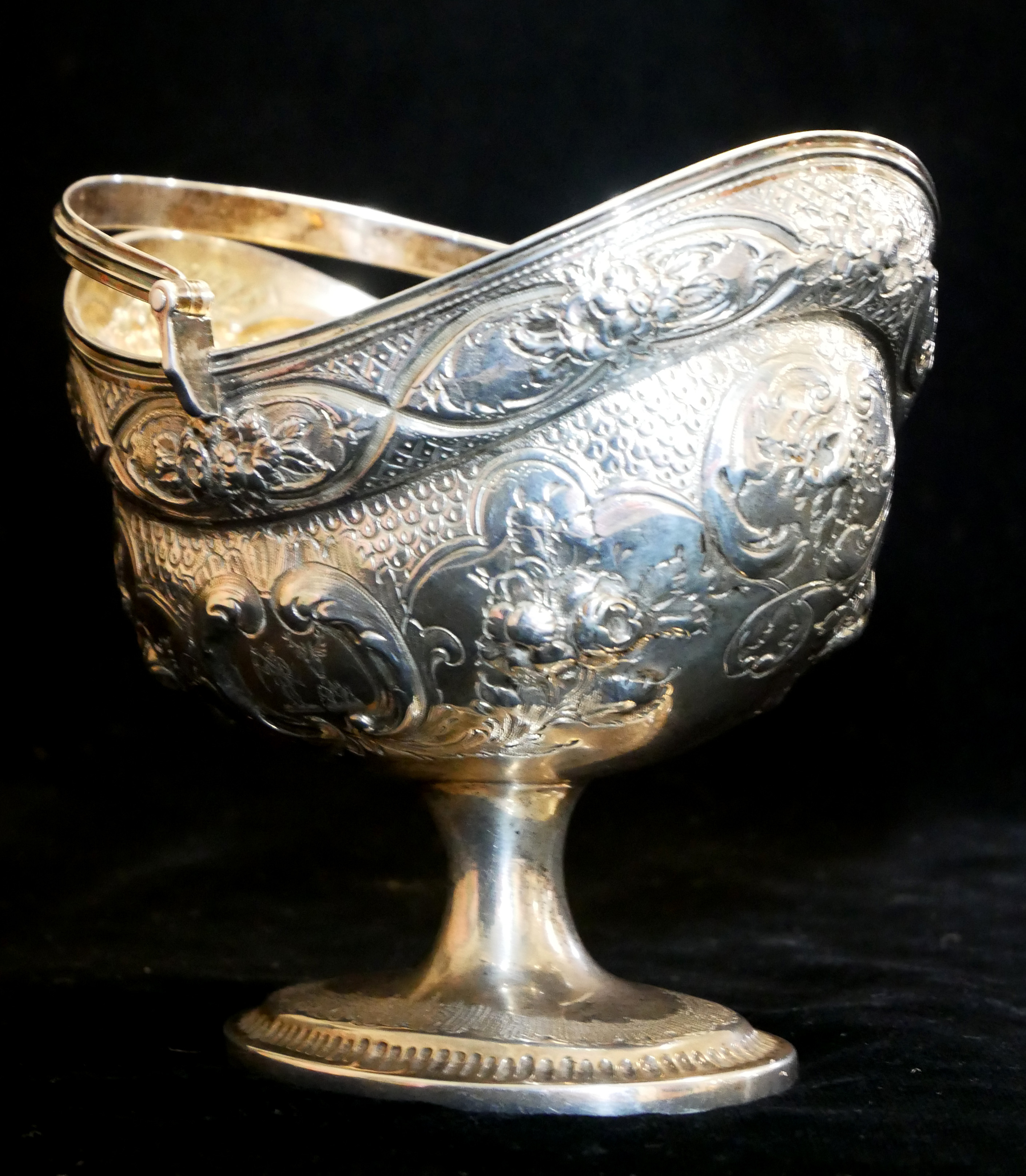 A GEORGIAN IRISH SILVER SWEETMEAT BASKET Having a swing handle, embossed floral decoration and - Image 2 of 5