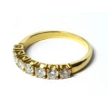 AN 18CT GOLD AND SEVEN STONE DIAMOND RING The single row of round cut diamonds (size Q). (approx