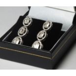 A PAIR OF 18CT WHITE GOLD AMD DIAMOND DROP EARRINGS, Three baguette cut stones edged with round