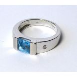 A 9CT WHITE GOLD, TOPAZ AND DIAMOND RING The Princess cut stone flanked by diamonds to shoulders. (