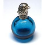 A WHITE METAL AND TURQUOISE GLASS BIRD FORM SCENT BOTTLE Having a bird form hinged lid and spherical