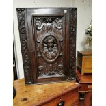 A VICTORIAN OAK WALL HANGING CORNER CABINET With single door carved with a facial mask. (60cm x 35cm