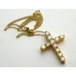 AN 14CT GOLD AND DIAMOND CRUCIFIX PENDANT The arrangement of round cut diamonds on fine link chain