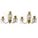 BACCARAT, A PAIR OF CRYSTAL AND GILT BRONZE THREE BRANCH WALL SCONCES Classical form hung with