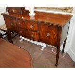 A REGENCY STYLE MAHOGANY SIDE CABINET Serpentine form, with central drawers flanked by cupboards.