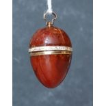 A GEORGIAN GOLD, AMBER AND ENAMEL EGG PENDANT The egg form amber pendant having a central gold and