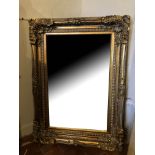 A 19TH CENTURY DESIGN GILT FRAMED MIRROR Deep cushion with foliage corners and shell decoration. (