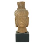 A HAND CARVED STONE HEAD OF A BUDDHA On exhibition stand. (31cm)