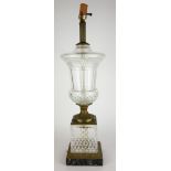 CLEAR CUT GLASS AND BRASS TABLE LAMP OF URN FORM On a black marble base. (65cm)