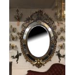 A LARGE ITALIAN INSPIRED OVERALL PARCEL GILT BEVELLED EDGE MIRROR Profusely decorated with foliage