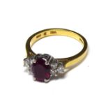 AN 18CT GOLD, RUBY AND DIAMOND RING The cabochon cut ruby flanked by diamonds (size N). (ruby approx